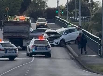 Police vehicles and damaged vehicles at the scene of a crash on Whitiora Bridge in Hamilton